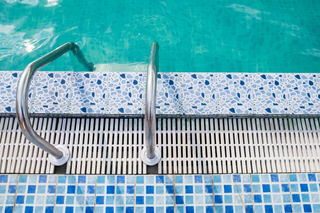 Contrast between pool grating and stone coping marking the pool edge on a swimming pool grating Singapore project